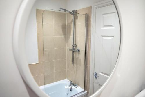 a bathroom with a shower and a bath tub at Denton House by Truestays - NEW 3 Bedroom House in Manchester in Manchester