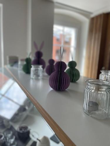a counter with several different colored vases on it at Hotel Anker in Rottenburg