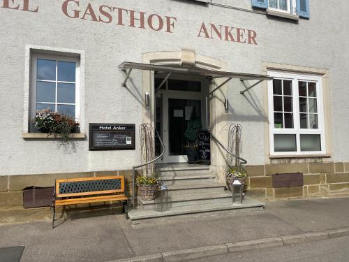 a building with a bench in front of a door at Hotel Anker in Rottenburg
