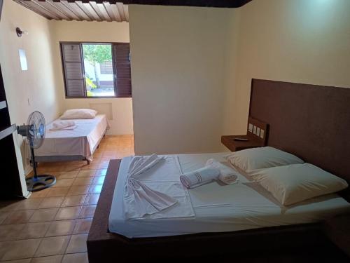 a bedroom with two beds and a fan at Hotel Comodoro De Livramento in Santana do Livramento