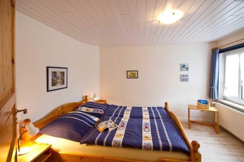 a bedroom with a bed with a blue comforter at Skuch-Looden in Süddorf