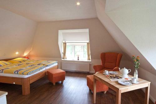 una camera da letto con un letto, un tavolo e una sedia di Auer-Werksteed a Süddorf