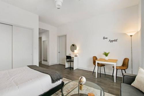 ein Schlafzimmer mit einem Bett, einem Tisch und einem Sofa in der Unterkunft Cozy & Comfy Studio Apartment - Del Prado 418 in Chicago