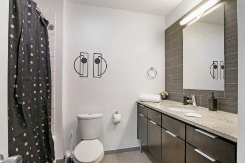 ein Badezimmer mit einem WC, einem Waschbecken und einem Spiegel in der Unterkunft Cozy & Comfy Studio Apartment - Del Prado 418 in Chicago