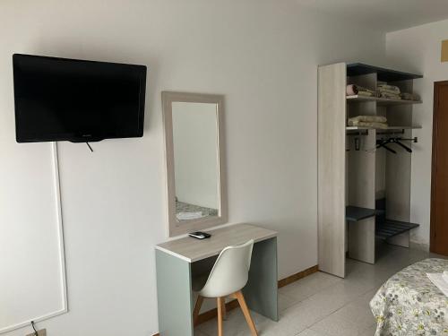 1 dormitorio con escritorio con silla y espejo en La voglia, en Villanova sullʼArda