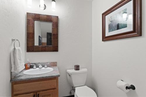 a bathroom with a toilet and a sink and a mirror at 4501 Spruce Way in Mid Vail