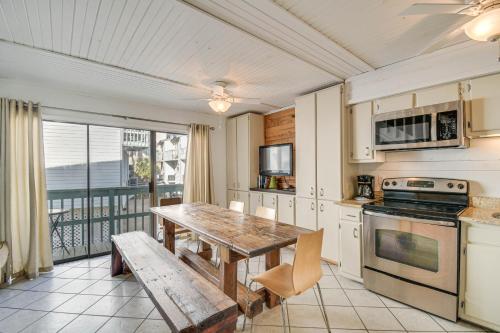 a kitchen with a wooden table and a wooden bench at Next to Gulf Shores Public Beach Condo with Pool! in Gulf Shores