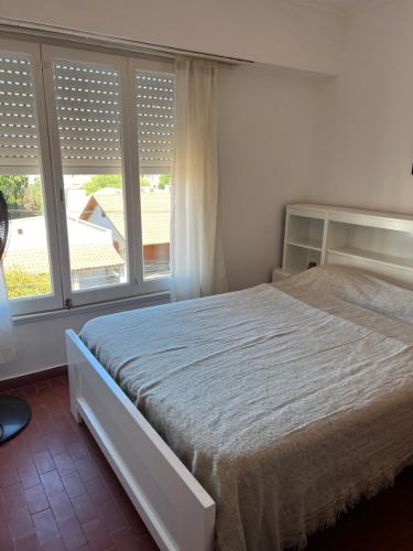 a bedroom with a bed and a large window at Departamento céntrico in Monte Hermoso