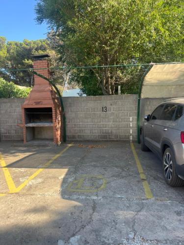 a car parked in a parking lot next to a brick wall at Departamento céntrico in Monte Hermoso