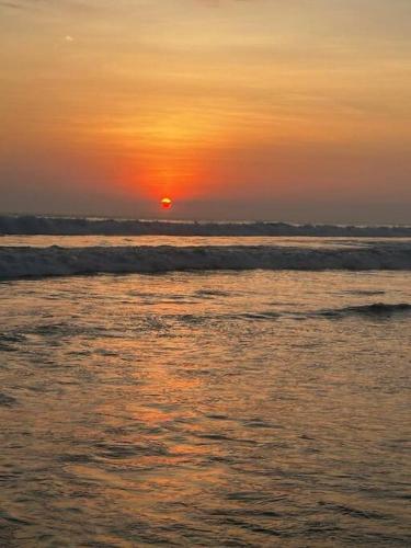 a sunset over the ocean with the sun in the horizon at Casa Bella in Jacó