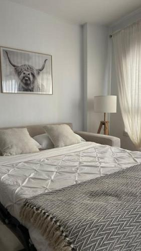 Schlafzimmer mit einem Bett mit einem Bild einer Kuh in der Unterkunft Fisco Apartamento in Puertito de Güímar