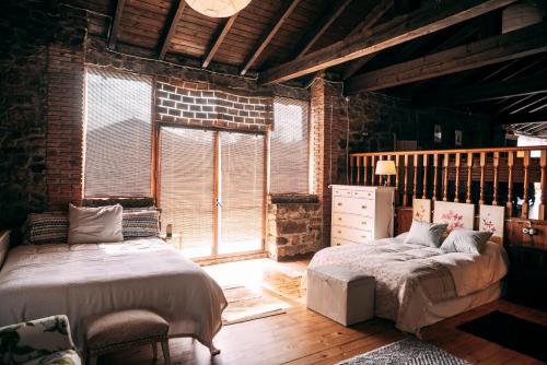 a bedroom with two beds and a brick wall at Casa Roma in Población de Abajo