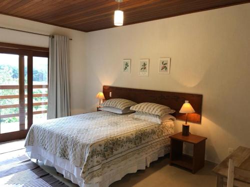una camera con un letto con due cuscini sopra di Villa Uliana - Bangalôs VILLA a Domingos Martins