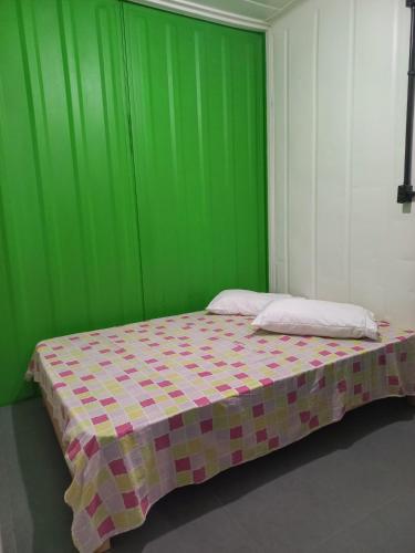 a bedroom with a green wall and a bed at Casa Container á 3minutos da Lagoa in Tapes