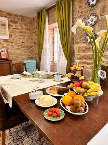 Una mesa con muchos platos de comida encima. en A Casa da Parrula, en Santiago de Compostela