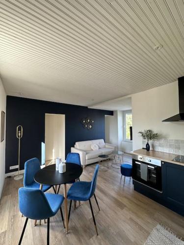 un salon avec une table et des chaises bleues dans l'établissement *CASA Ushuaia*, à Cholet