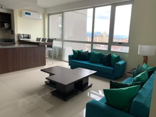 uma sala de estar com dois sofás azuis e uma mesa em HOTEL BRIZO DEPARTAMENTO PARTICULAR em Salta
