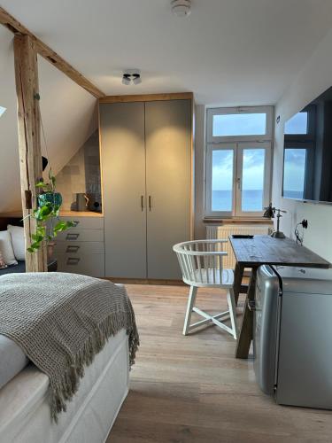 a bedroom with a bed and a desk and a table at Strandhaus WOTAN in Kühlungsborn