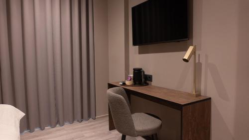 a room with a desk with a chair and a television at Hotel Nørreport in Holstebro