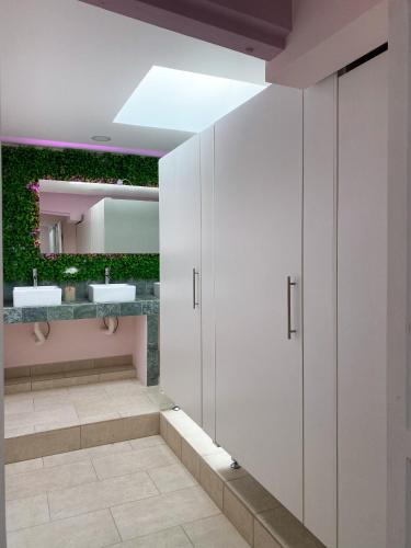 a bathroom with two sinks and a green wall at Casa Pandora Hostel Women Only in San José