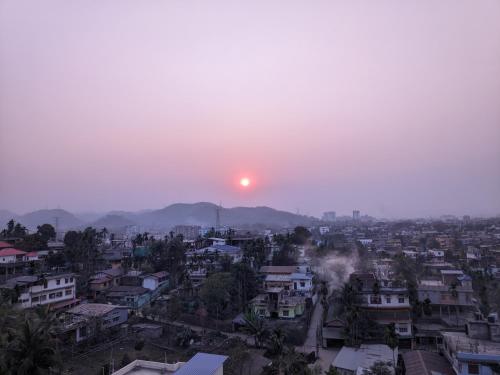 a view of a city with the sun in the sky at Countryside Inn in Guwahati