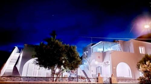 un gran edificio blanco con un árbol delante en DP Homes Studio Mimika Santorini en Perissa