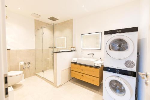 a bathroom with a washing machine and a washer at LELA Apartments Chiemsee in Bernau am Chiemsee