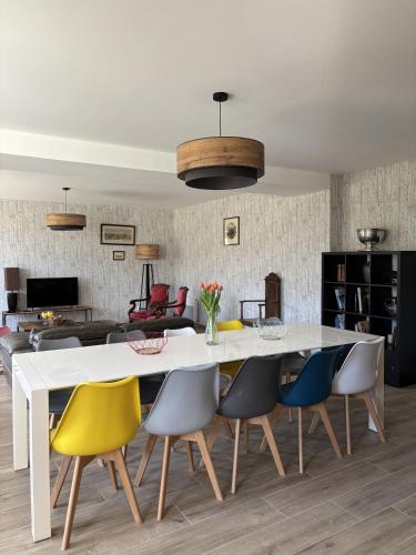 une salle à manger avec une table et des chaises blanches dans l'établissement La Gravette, 10mn du ZooParc de Beauval, à Faverolles