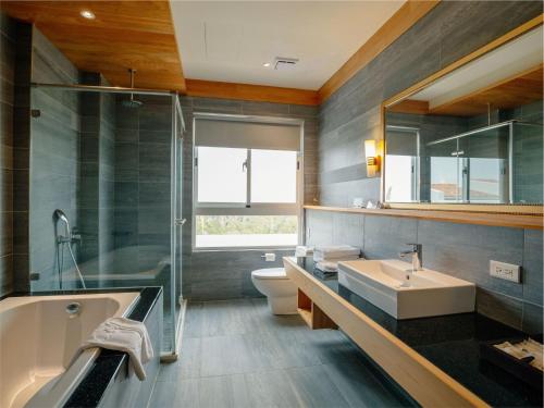 a bathroom with a sink and a tub and a toilet at Bay Forest Boutique B&B in Hengchun