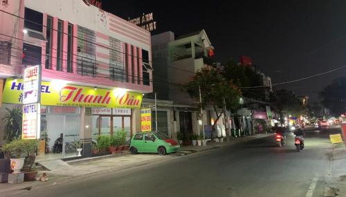 a city street at night with a car and motorcycles at Hotel Thanh Vân in Thuan An