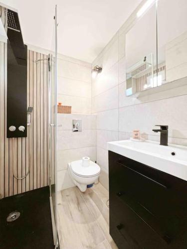 une salle de bain blanche avec des toilettes et un lavabo dans l'établissement Le Bruna: Apt 4 prs, Clim, 10 min plages, à Antibes