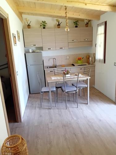 - une cuisine avec une table et des chaises dans la chambre dans l'établissement CAMPEGGIO PARCO DEI PINI, à San Feliciano