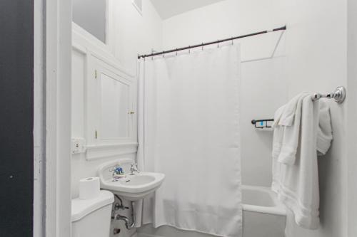 a white bathroom with a sink and a toilet at Library Square Suites in Toledo