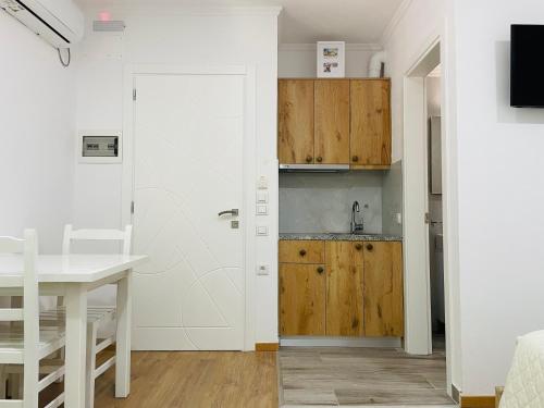 a kitchen with a white door and a table at Guesthouse near the Castle of Himare in Himare