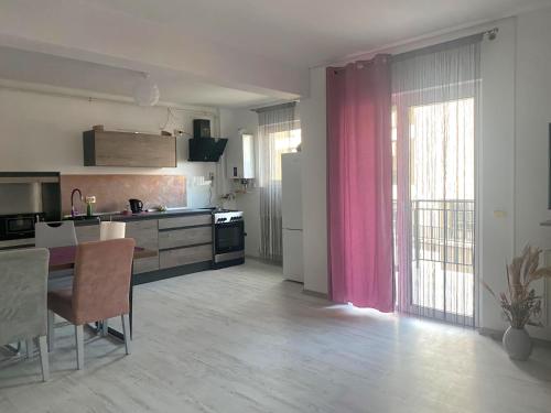 cocina con mesa y cortina rosa en RMS Residence, en Floreşti
