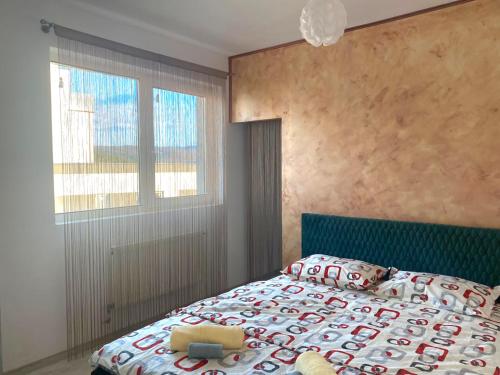 1 dormitorio con 1 cama con cabecero azul y ventana en RMS Residence, en Floreşti