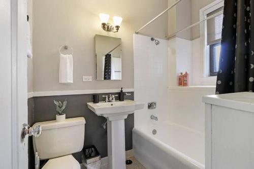 a bathroom with a toilet and a sink and a tub at Prime & Fully Furnished Studio Apartment - Windermere 609 in Chicago