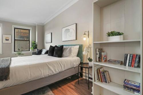 a bedroom with a bed and a book shelf at Prime Studio Fully Furnished Apartment - Windermere 609 in Chicago