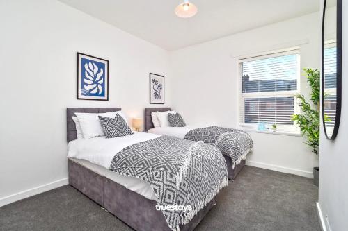 - une chambre avec 2 lits et une fenêtre dans l'établissement Nursery House by Truestays - 3 Bedroom House in Stoke-on-Trent, à Stoke-on-Trent