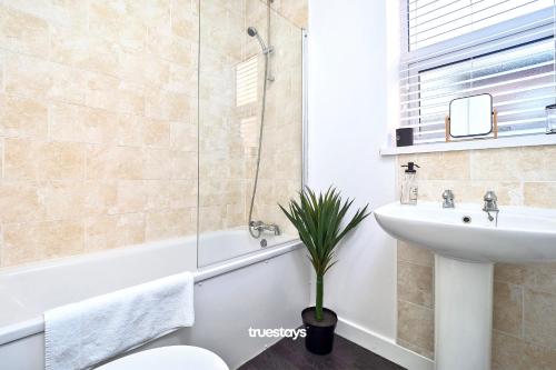 a bathroom with a tub and a sink and a toilet at Nursery House by Truestays - 3 Bedroom House in Stoke-on-Trent in Stoke on Trent