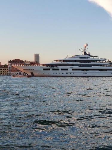a large yacht sitting in the water near a city at #Punto FM 2# in Marghera