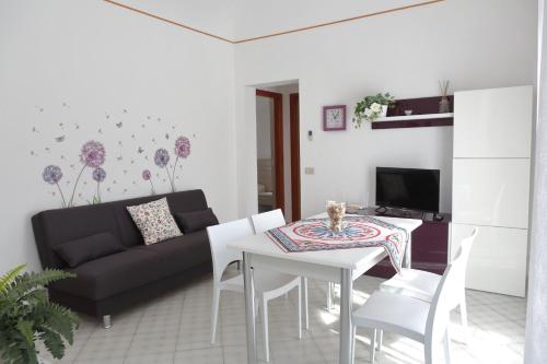 een woonkamer met een tafel en een zwarte bank bij Terrazza del Cortile - by Vacation Service in Cefalù