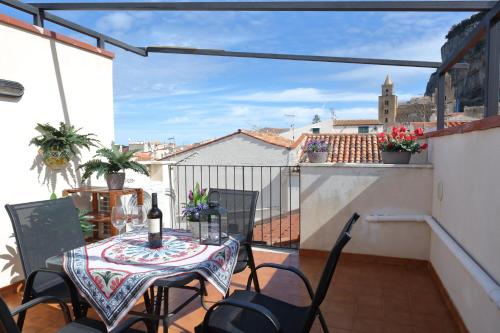 un patio con tavolo e sedie sul balcone. di Terrazza del Cortile - by Vacation Service a Cefalù