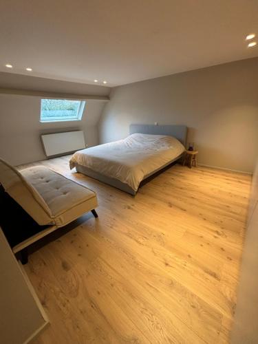 1 dormitorio con 1 cama y suelo de madera en 't Urbain - Vakantiewoning en Oudenaarde