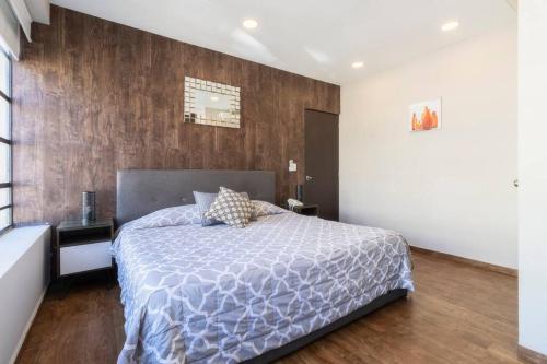 a bedroom with a bed and a wooden wall at 401 Location 3Bdrm 2bath apt with AC Rooftop in Mexico City