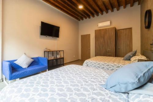 a bedroom with two beds and a tv on the wall at 105 Centrico Zocalo apt 2Bdrm 2bath AC Rooftop in Mexico City