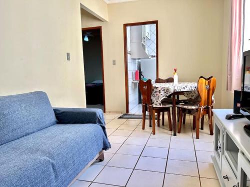 uma sala de estar com um sofá, uma mesa e cadeiras em Apartamento Mobiliado em Piracicaba Centro em Piracicaba