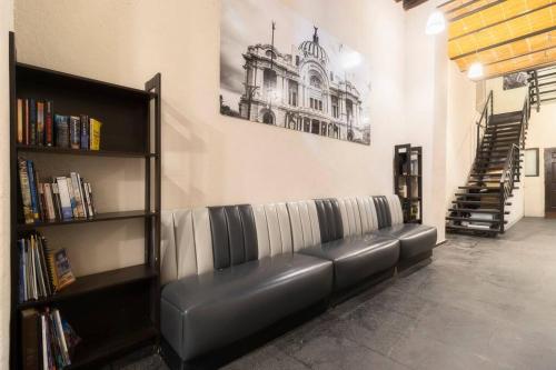 a black leather couch in a room with a book shelf at 304 Balcony apt Walk to Zocalo AC Rooftop in Mexico City
