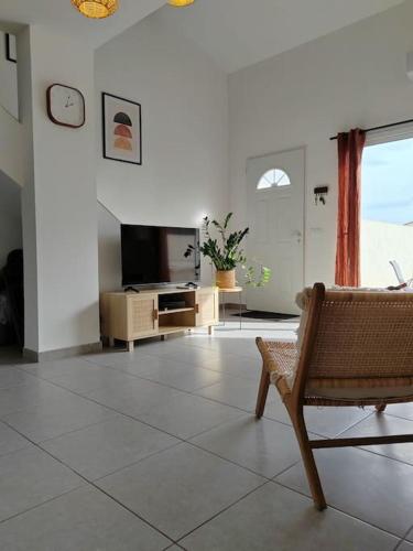 un salon avec une télévision et une chaise dans l'établissement Chez Roberto/Jardin/Parking, à Fos-sur-Mer