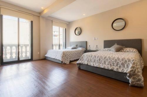 a bedroom with two beds and a large window at 406 Location 2Bdrm 2baths AC Rooftop in Mexico City